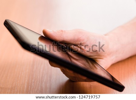 A man holds up and running on a Tablet PC