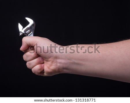 The wrench in his hand on a black background
