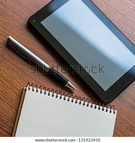 Tablet PC, notebook and pen a book on an office desk