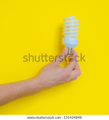 Light bulb in hand on a yellow background