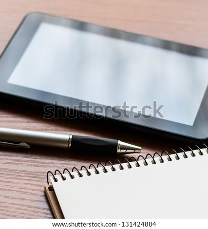 Tablet PC, notebook and pen a book on an office desk