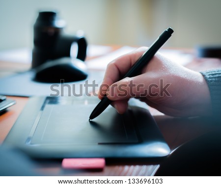Graphic designer using digital tablet and computer in the office