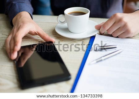 businessman using a tablet and drinking coffee