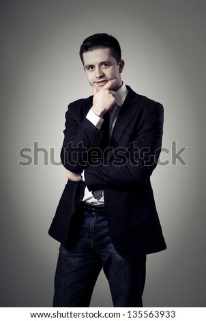 Young businessman thinking on a gray background