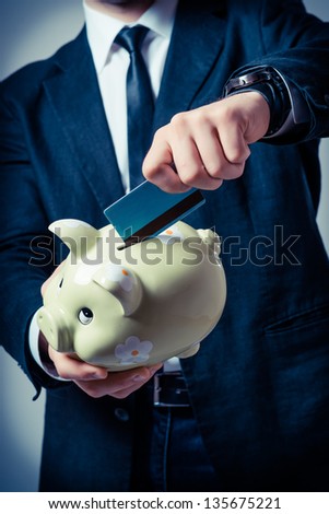 Man with piggy bank and credit card