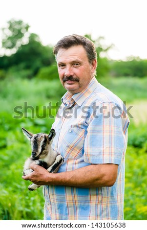 man holding a goat in his arms