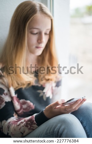 Young beautiful woman writes an SMS to your mobile phone