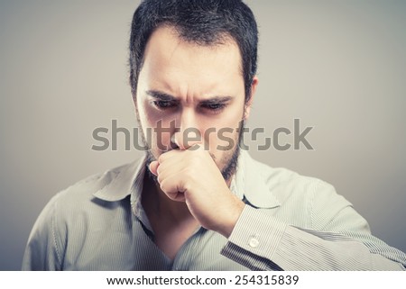 Young handsome man covered her mouth in surprise. Gesture. On a gray background