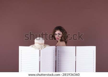 young woman looking behind the folding screen