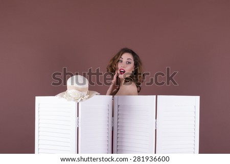 Surprised woman looking behind the folding screen
