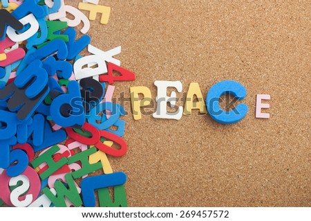 Colourful word peace with cork board as background