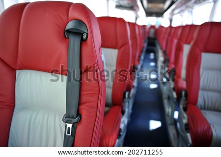 red leather seats with seat belts in a tourist bus
