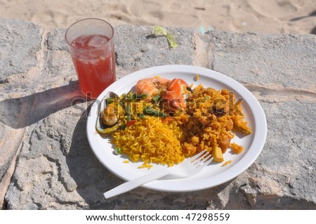 Mexican Dinner. A white dish, rice, sea products and a fruit drink in a glass.