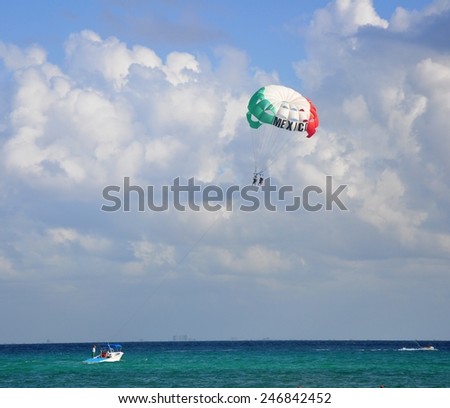 Under a colored dome. A walking parachute over the sea and the boat pulling it for itself.