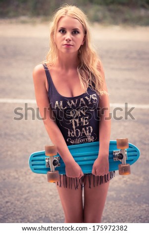 Beautiful young girl hipster with skateboarding in the afternoon. Outdoors, lifestyle