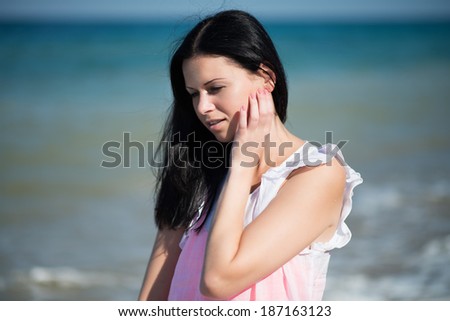 Happy woman rest on a beach. Portrait of the beautiful girl close-up, the wind fluttering hair.