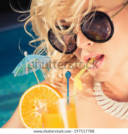 beautiful, suntanned, young sexy woman drinking cocktail, and enjoys in the summer afternoon near the pool. Photo with instagram style filters