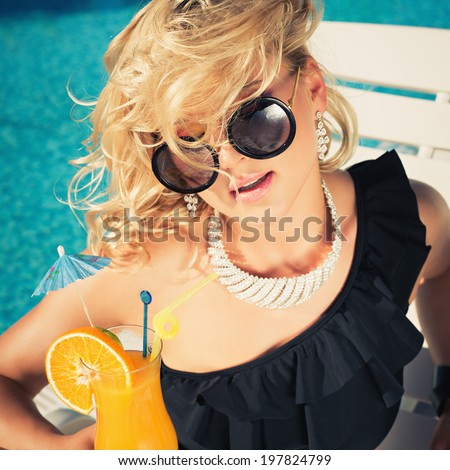 beautiful, suntanned, young sexy woman drinking cocktail, and enjoys in the summer afternoon near the pool. Photo in color instagram filters style