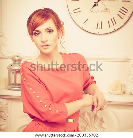 Beautiful young fashionable woman posing in red dress. Looking at camera. Vogue style. Photo with instagram style filters