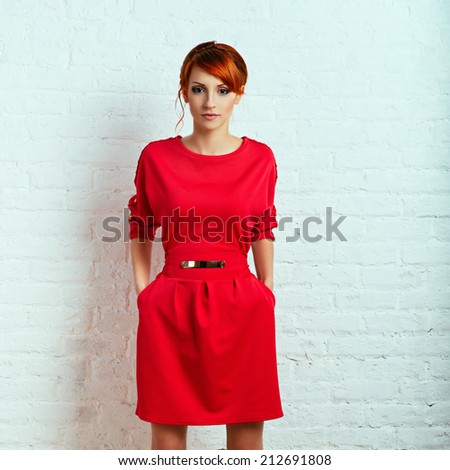 Beautiful young fashionable woman posing in red dress, smiling, looking at camera. Vogue Style. Photo with instagram style filters