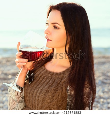 beautiful young woman holding glass of red italian wine. sunset. Photo with instagram style filters