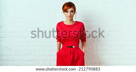 Beautiful young fashionable woman posing in red dress, smiling, looking at camera. Vogue Style.