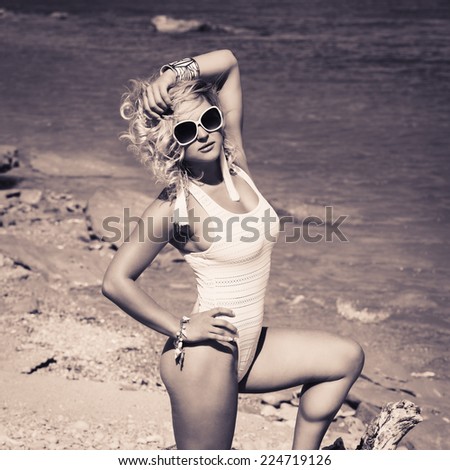 Woman with beautiful body on a tropical beach. beautiful young woman in a white bathing suit relaxing on the beach. black and white. Photo with instagram style filters
