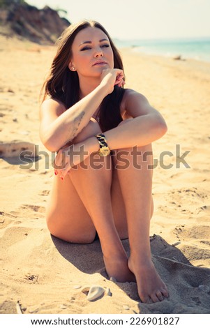 Sexy woman with beautiful body on a tropical beach. beautiful young woman in a white bathing suit relaxing on the beach. Vogue style
