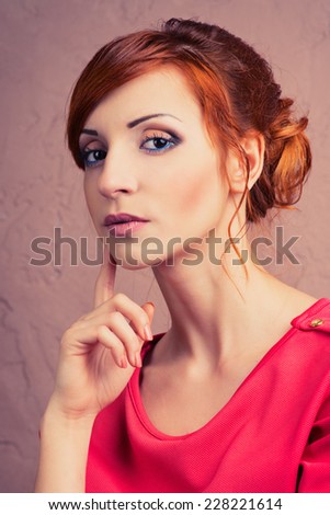 Beautiful young fashionable woman posing in red dress, smiling, looking at camera. Vogue Style
