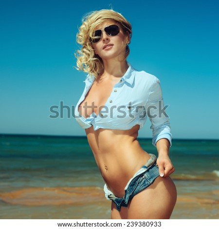 pretty woman in sexy shorts posing at beach. Fashion summer outdoor portrait. Photo with instagram style filters