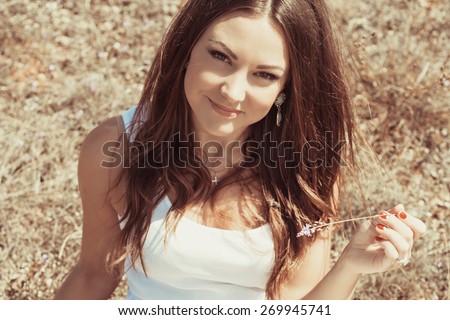 Beautiful young woman lying on the grass enjoying summer sun. girl in a long skirt and with long hair poses in warm spring day