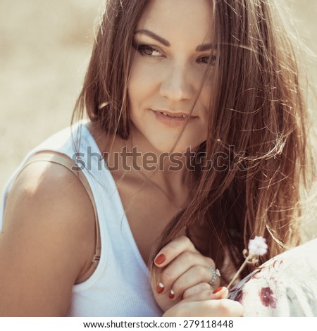 Portrait of the young beautiful smiling woman outdoors enjoying summer sun. wind in hair. girl in a long skirt and with long hair poses in warm spring day. Photo with instagram style filters