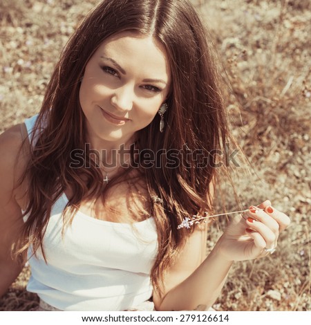 Beautiful young woman lying on the grass enjoying summer sun. girl in a long skirt and with long hair poses in warm spring day. Photo with instagram style filters