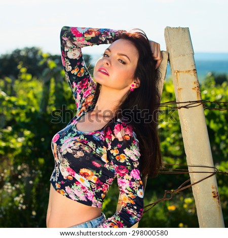 Sexy beautiful attractive brunette woman with slim tanned body, long developing hair, clean face posing outdoor enjoys fine warm summer weather. instagram style