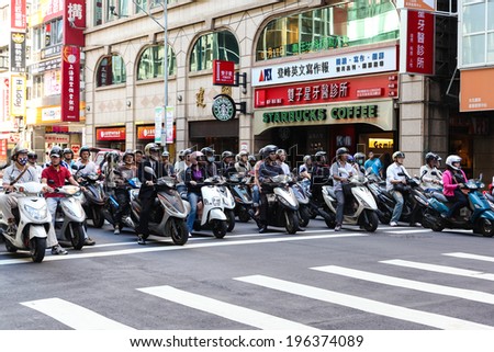 TAIPEI, TAIWAN-JULY 16: Scooter riders stop at a traffic junction in Taipei City July 16, 2013. Taiwan has 15 million registered scooters, which accounts for nearly one scooter for every adult person.