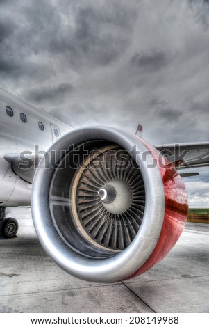 HDR rendering of an airplane engine on the tarmac of an airport. Vertical orientation with copy space.