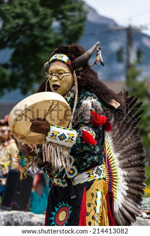BANFF, CANADA - JUL 3: A native Blackfoot Indian chief wearing a split-horn bonnet dances during a performance at the Banff Summer Arts festival July 3, 2014.