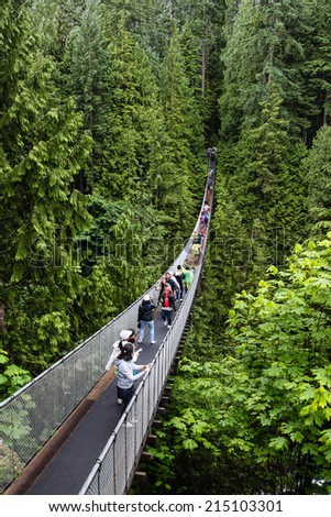 VANCOUVER, BRITISH COLUMBIA - JUN 29: Visitors crossing the Capilano River on a suspension bridge June 29 2011 in North Vancouver. The Capilano Suspension Bridge is 460 feet long and 230 metres above the river.