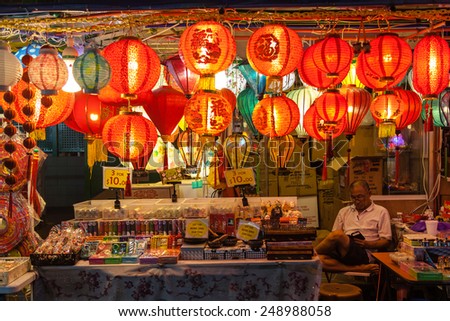 SINGAPORE - DECEMBER 12: A street vendor in Chinatown watches over his store selling Chinese lanterns December 12, 2014. Paper lanterns are popular during Chinese New Year and Mid-Autumn Festivals.