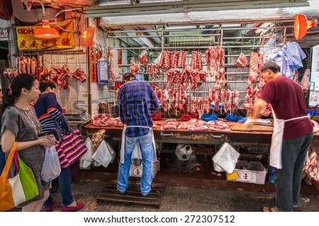 HONG KONG - MARCH 30: Butchers cut up pork for customers on Gage Street Mar. 30, 2015. The popular area was Hong Kong\'s oldest continuously operating street market for 160 years.