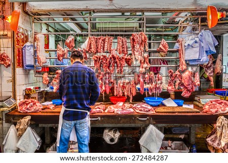 HONG KONG - MARCH 30: Butchers cut up pork for sale on Gage Street in the Central District Mar. 30, 2015. The area was Hong Kong\'s oldest operating street market for 160 years until March 30, 2015.