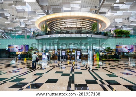 SINGAPORE - MARCH 24 : Travelers walk about Singapore Changi Airport\'s departure hall Mar. 24, 2015. With three passenger terminals, it is one of the largest transportation hubs in Asia.