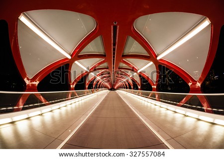 Night view of Calgary\'s Peace Bridge. The bridge features a red and white helix design. Opened in March 2012, it connects the extensive Bow River Pathway on the north and south sides of the Bow River.