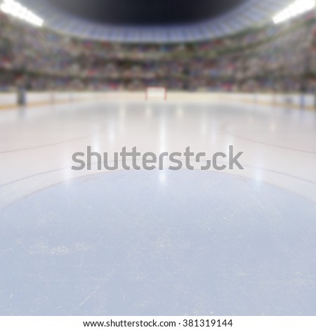 On ice low-angle view of a dramatic hockey arena full of fans in the stands with copy space. Deliberate focus on foreground ice and shallow depth of field on background with lighting flare effect.