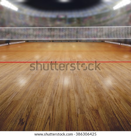 Volleyball arena full of fans in the stands with deliberate focus on foreground and shallow depth of field on background net and court. Floodlights flare for effect and copy space.