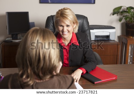 A business woman finishing the paperwork to a sale with a client.