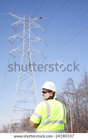 LOUISVILLE - 31 JANUARY: Pike Electric Supervisor, Tom Wallace, watches the work area as a worker repairs the top of a high tension line tower after ice damage from January 2009 storm.