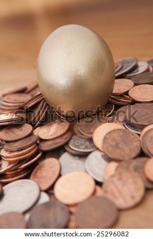 Golden egg nested on pile of coins