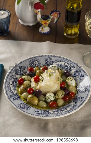 A typical Portuguese dish with codfish called Bacalhau do Porto in a original portuguese plate.