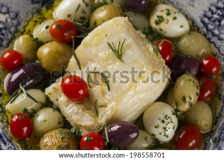 A close up of a typical Portuguese dish with codfish called Bacalhau do Porto in a original portuguese plate seen from above.